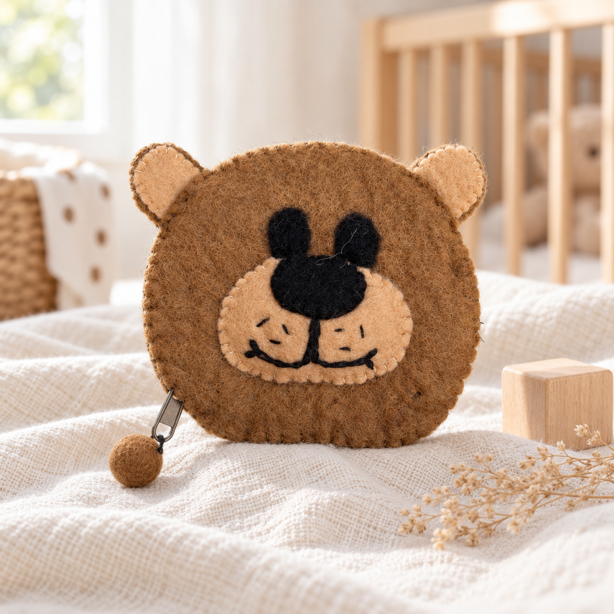 Felt brown bear coin purse in a warm nursery setting