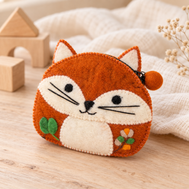 Felt fox coin purse styled on a pale wooden table