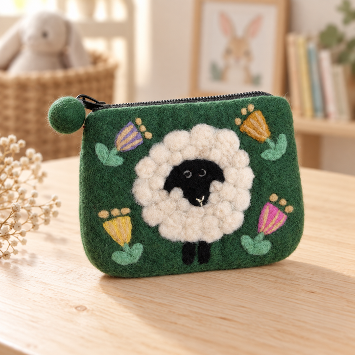 Green floral felt sheep coin purse styled on a pale wooden table
