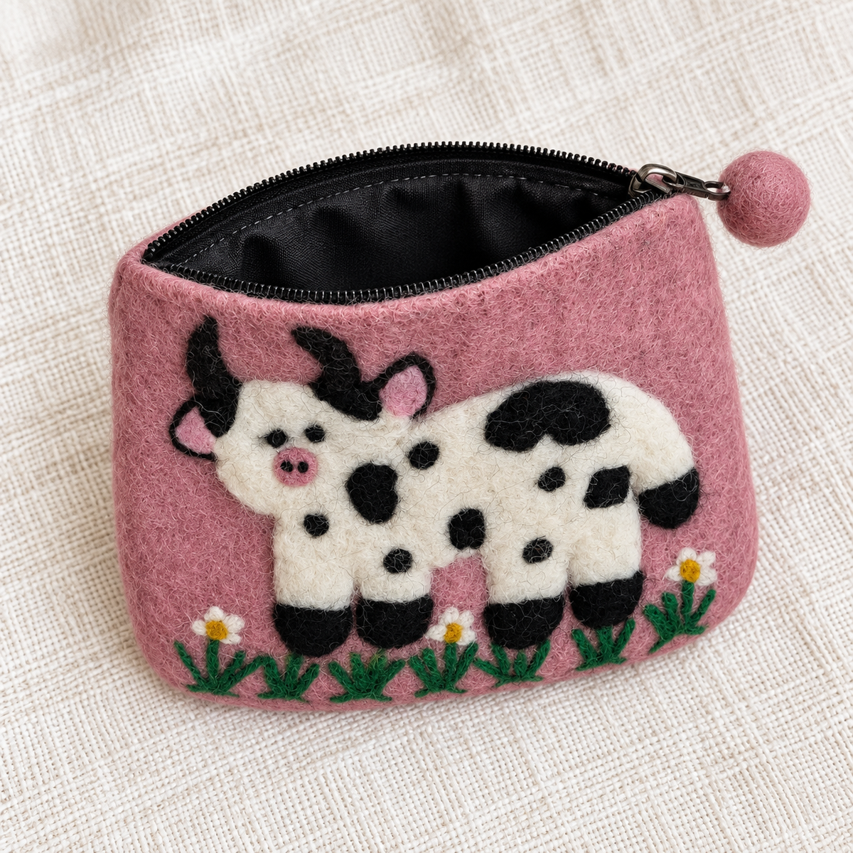 Open pink cow felt coin purse showing black lining