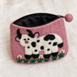 Open pink cow felt coin purse showing black lining