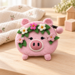 Pink felt pig coin purse styled on a pale wooden table