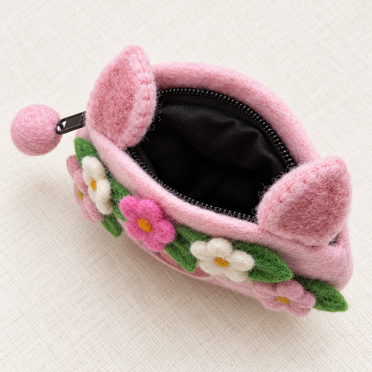 Open pink felt pig coin purse showing black zip and lining