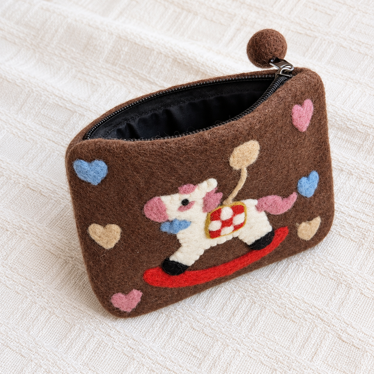 Open brown felt rocking horse coin purse showing black zip and lining